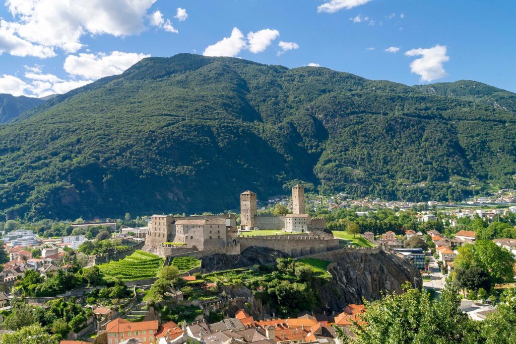 O Castelgrande erguendo-se sobre a cidade de Bellinzona, no Ticino, com as suas torres de pedra ao pé da montanha