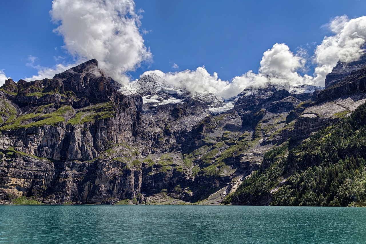 Lago Oeschinensee diante de paredões rochosos e montanhas sob nuvens