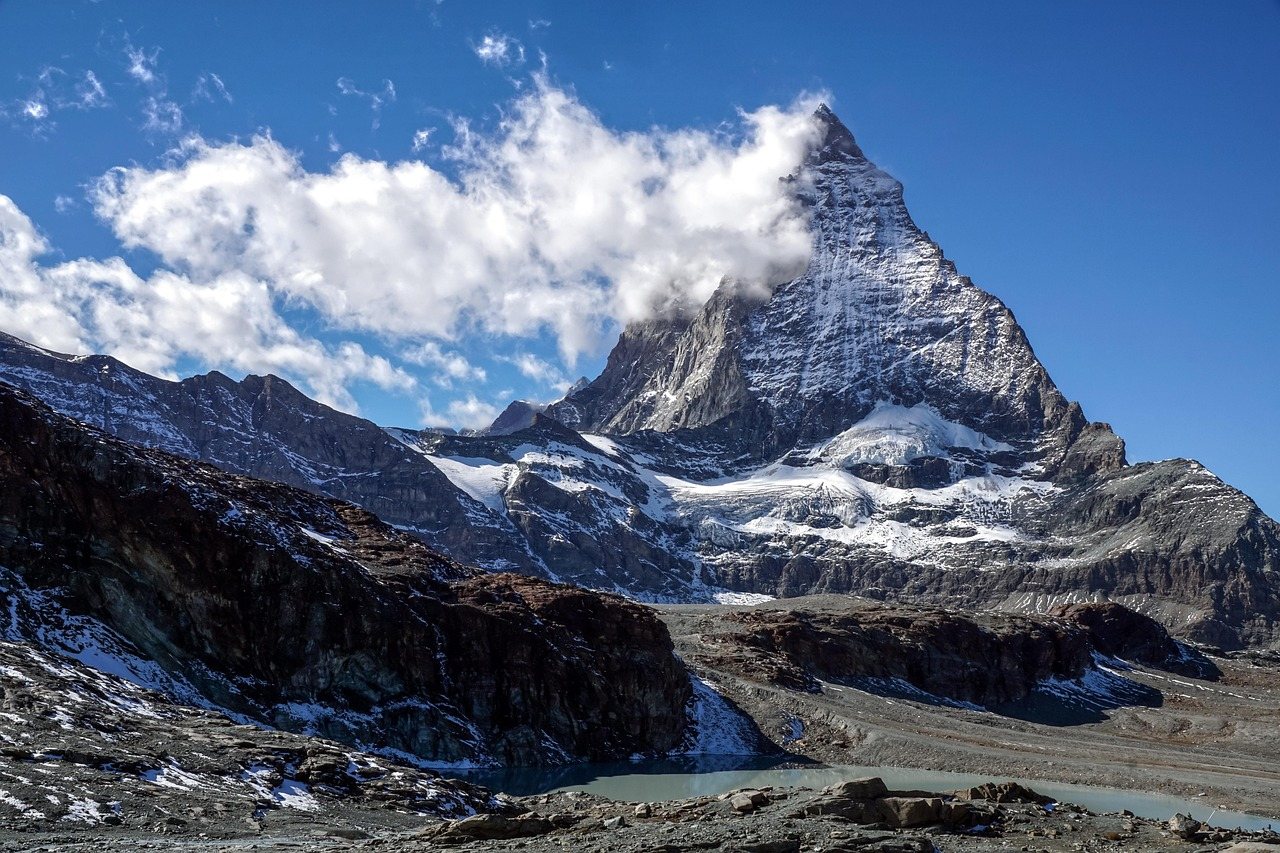 O Matterhorn em forma de pirâmide, com um pequeno lago glacial em primeiro plano, no Valais, Suíça