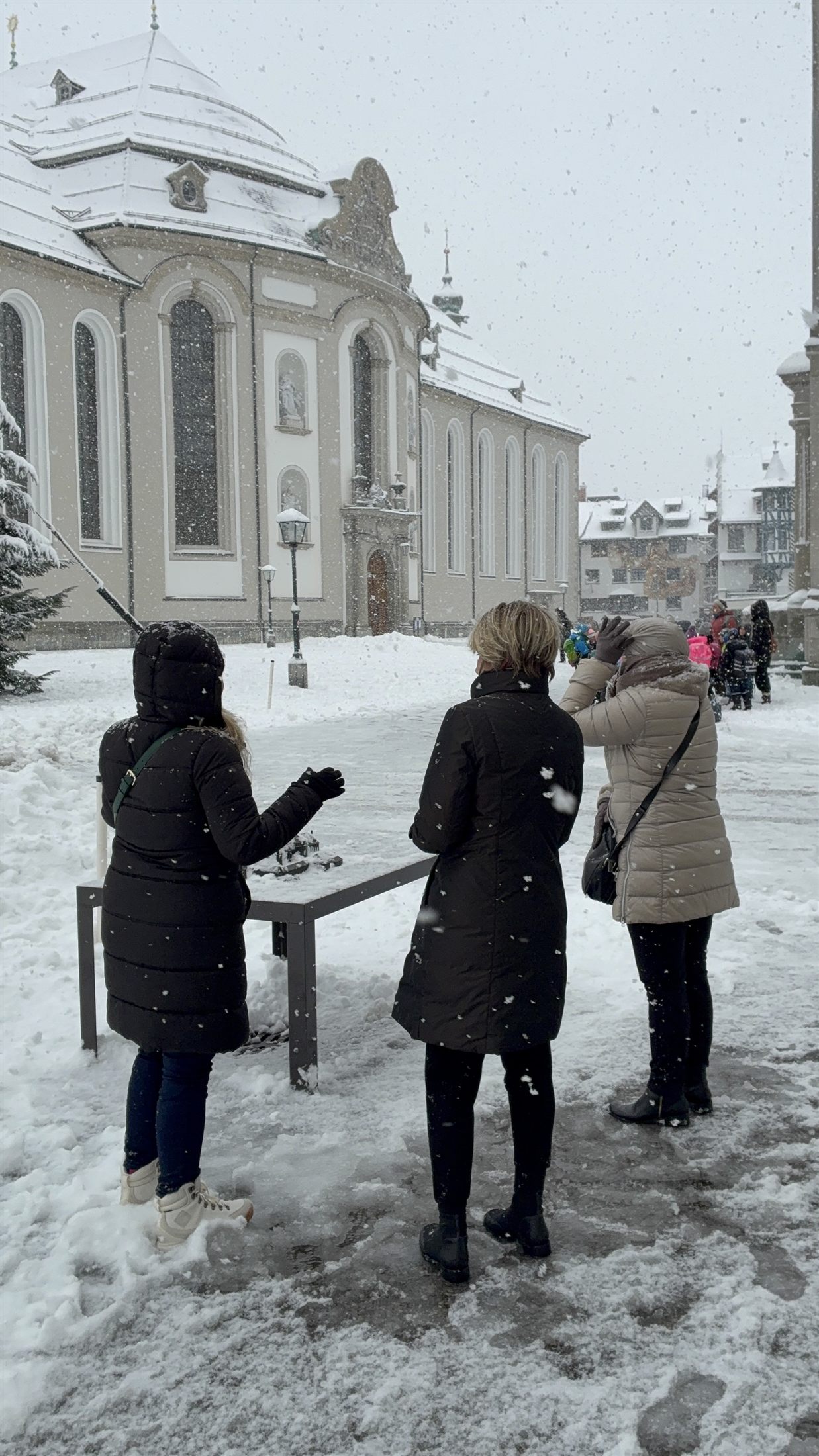 Vista panorâmica da grande praça de Einsiedeln no inverno, com a igreja abacial barroca à esquerda e o mosteiro ao fundo