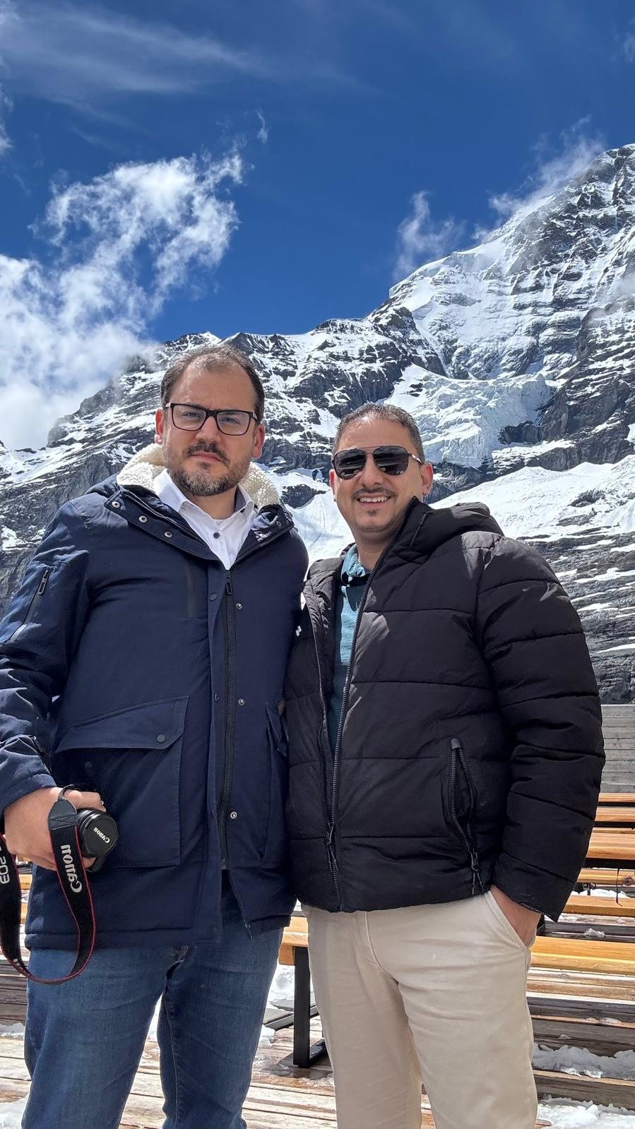 A dupla da Viagem Suíça na subida ao Jungfraujoch, com o maciço nevado do Eiger ao fundo