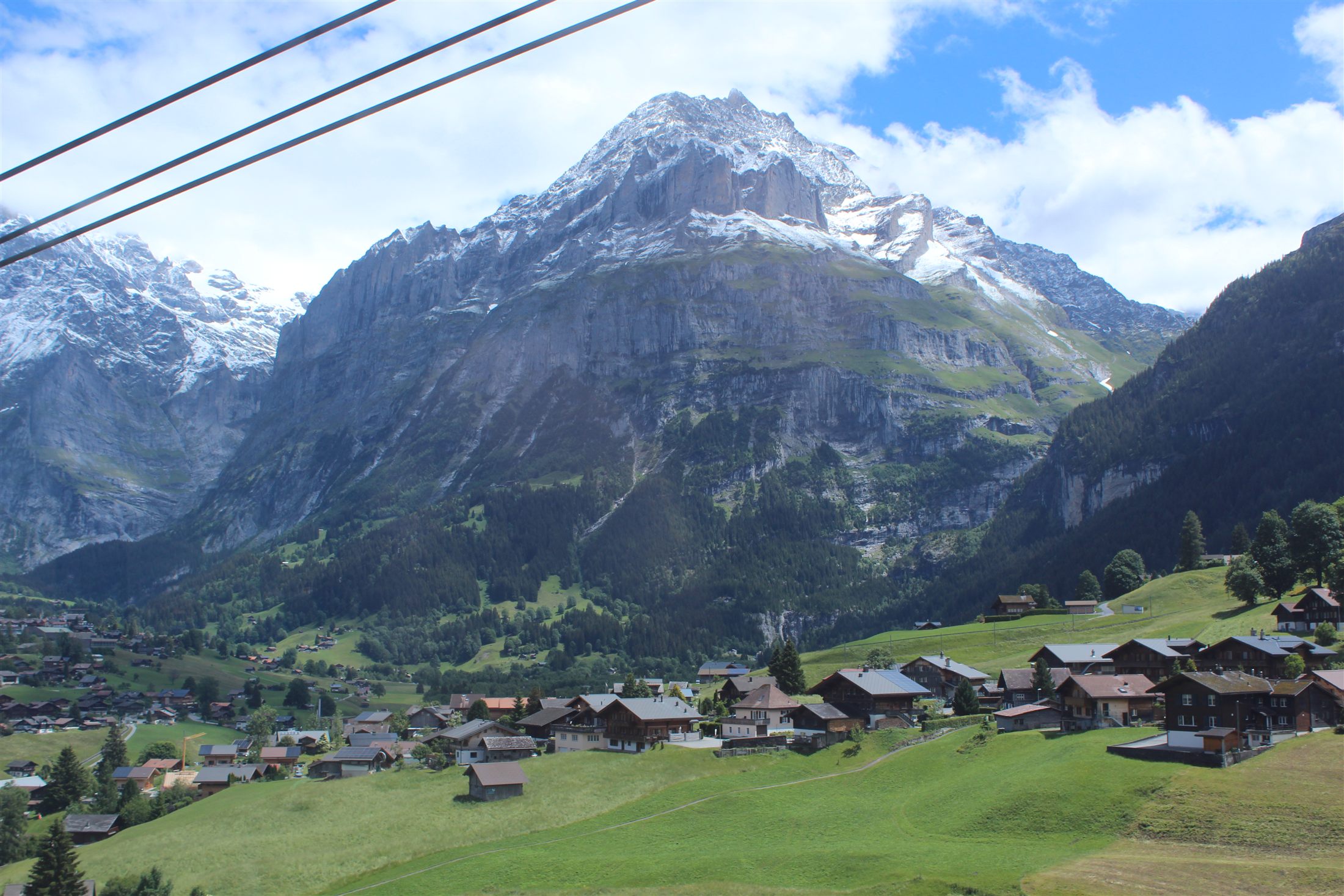 Vila de Grindelwald no vale com a parede norte do Eiger nevada à direita