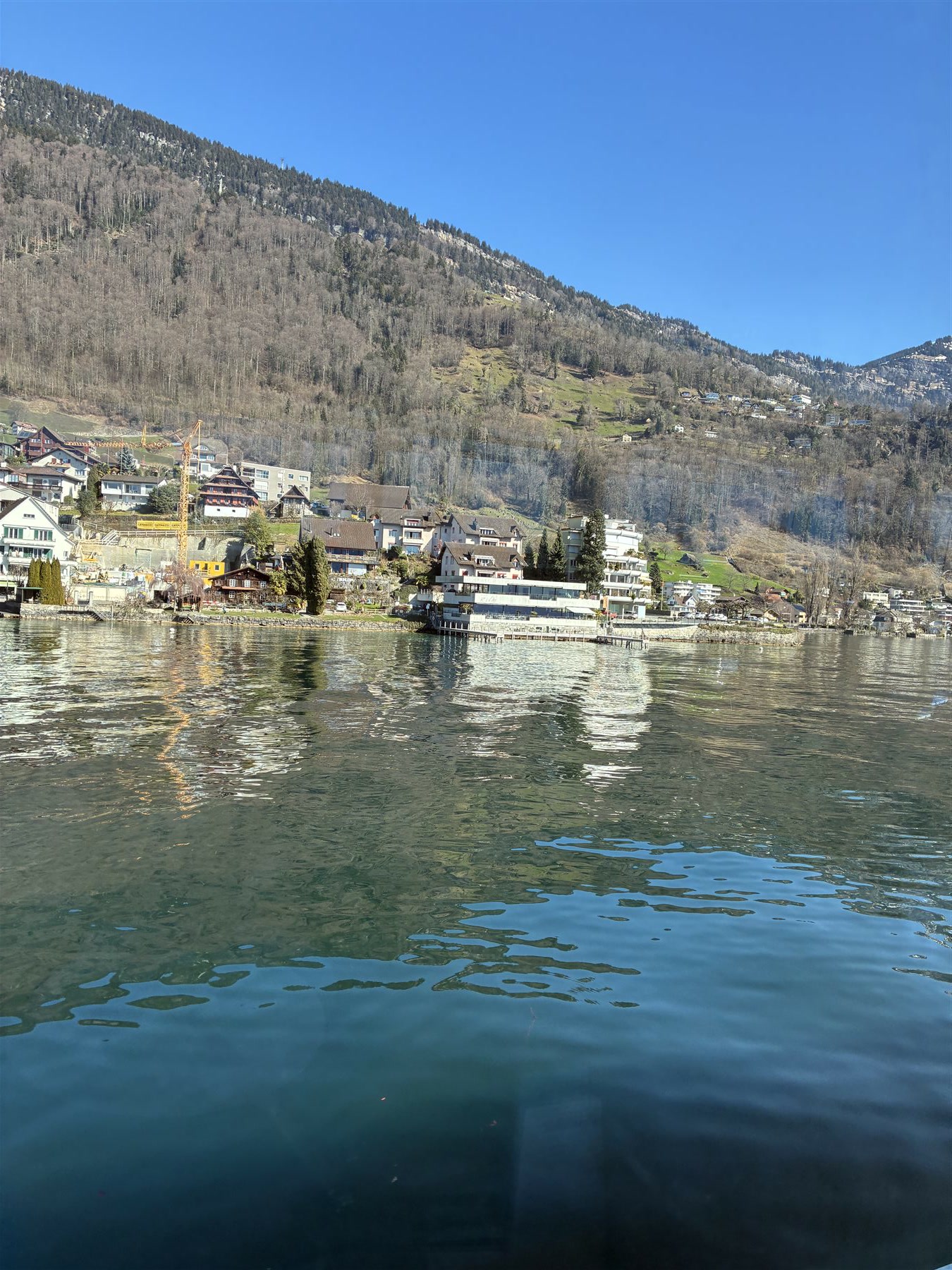 Aldeia suíça refletida nas águas calmas de um lago alpino