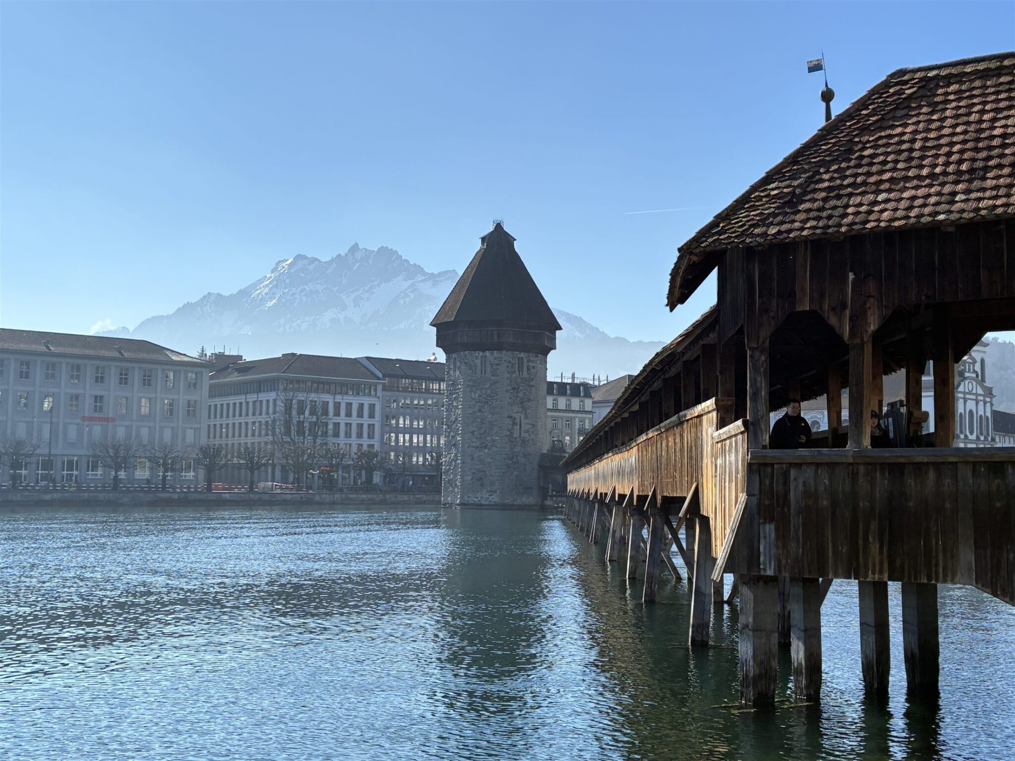 Vista clássica da Kapellbrücke, a ponte coberta de madeira de Lucerna, sobre o rio Reuss com a Torre d'Água