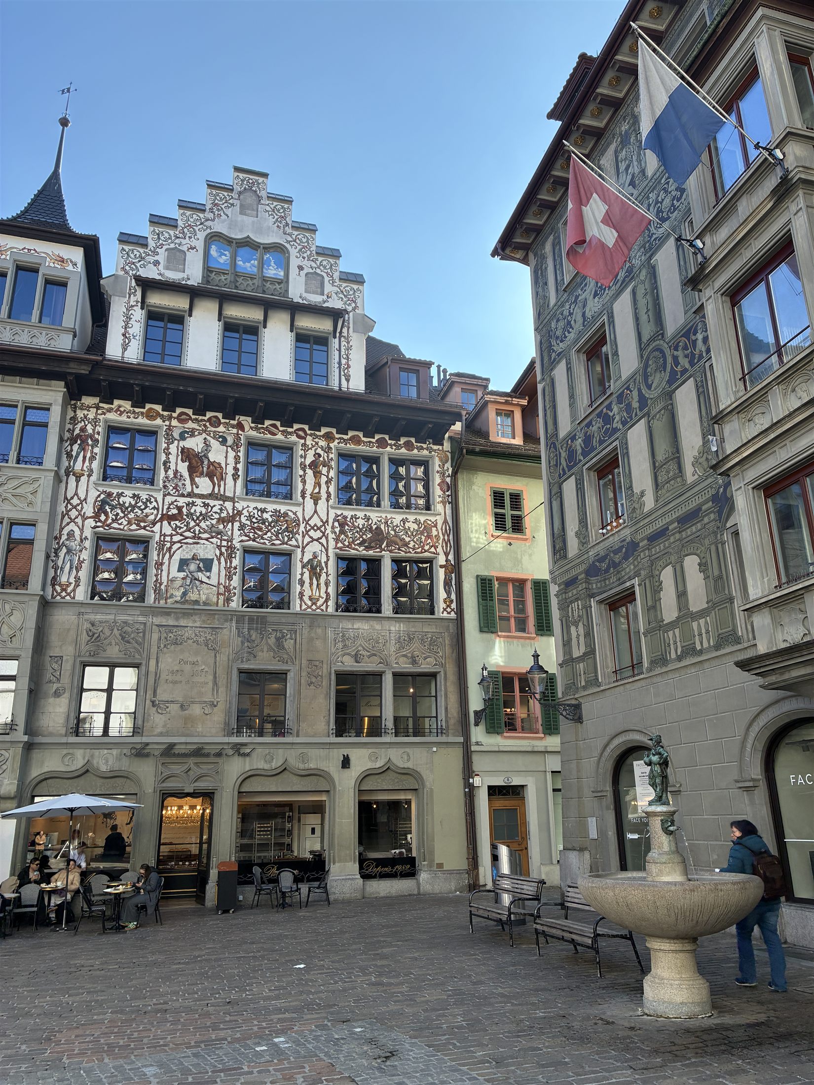 Praça Weinmarkt em Lucerna, com fachadas históricas pintadas com motivos medievais