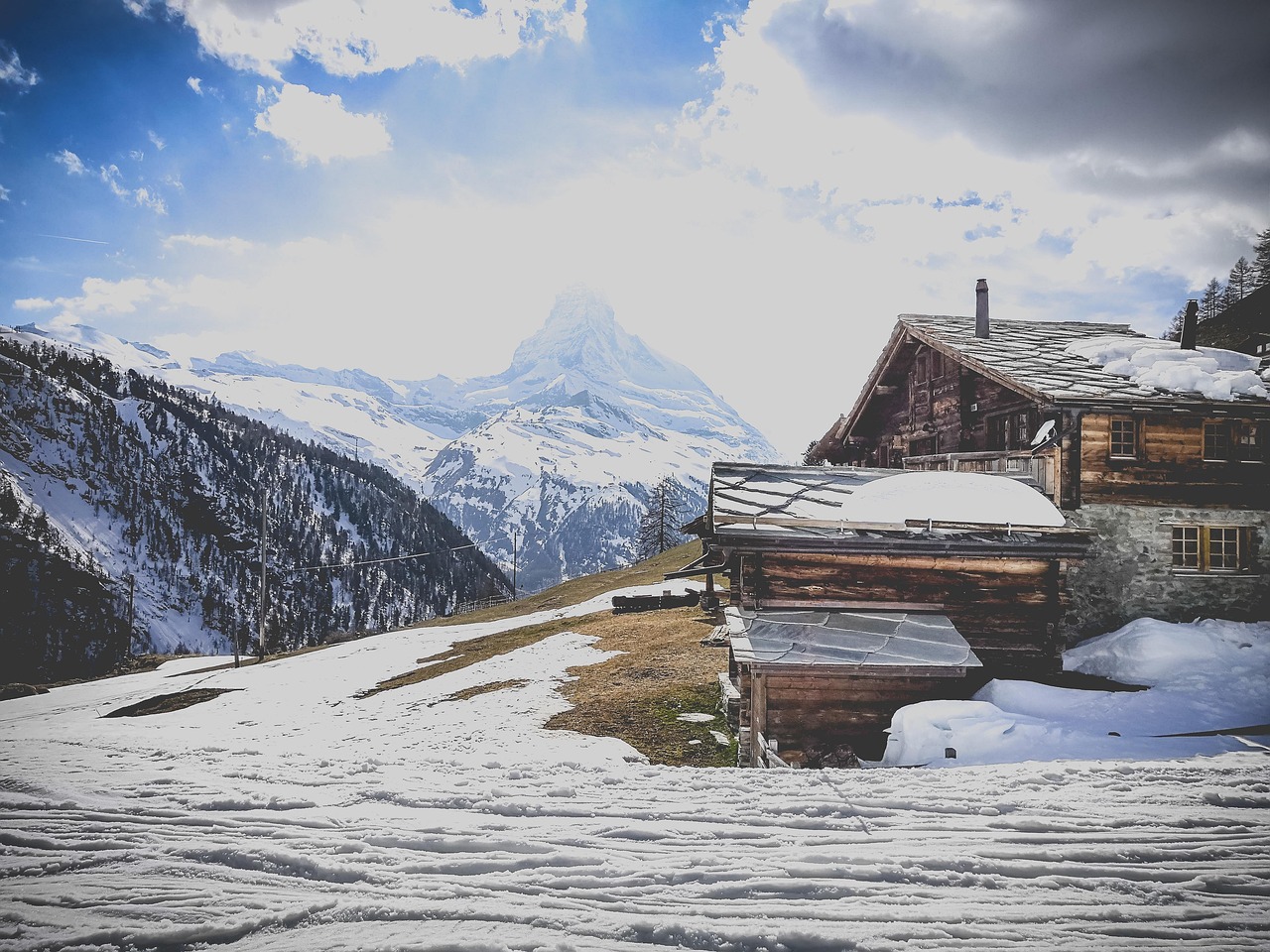 Chalé tradicional de madeira numa encosta elevada acima de Zermatt, com o Matterhorn ao fundo sem obstruções