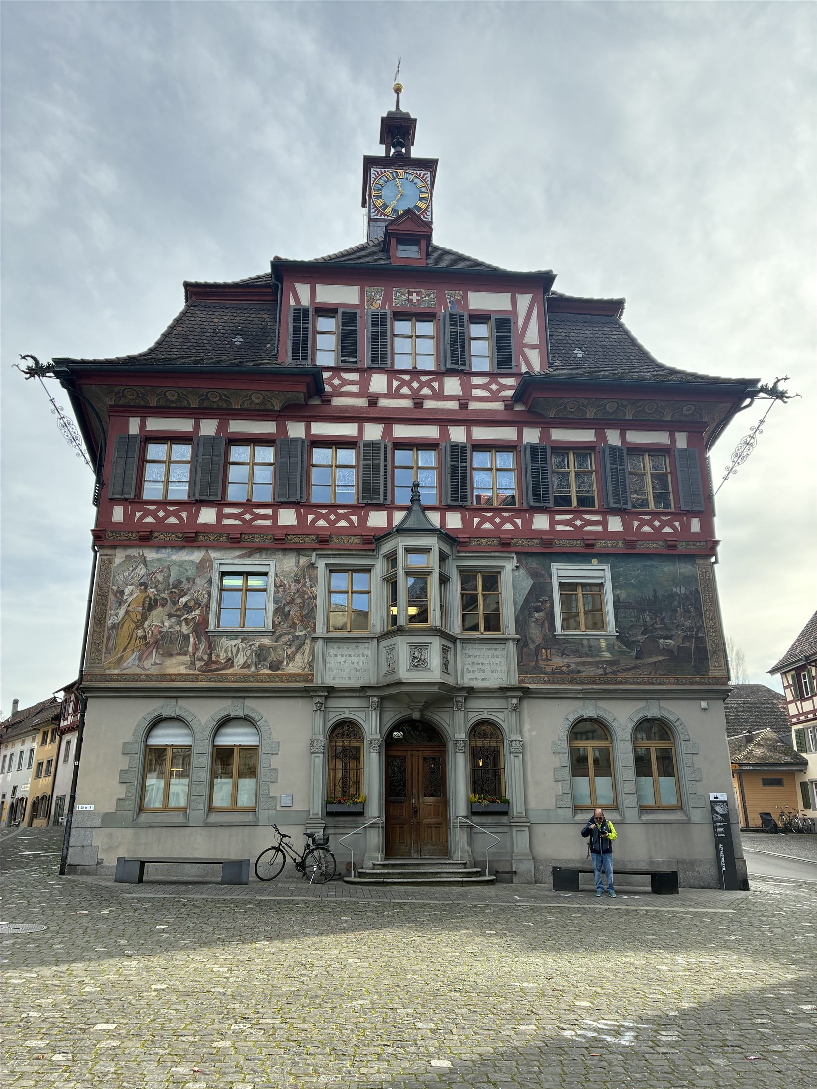 Beco estreito entre edifícios históricos de Stein am Rhein revelando a torre da igreja do mosteiro