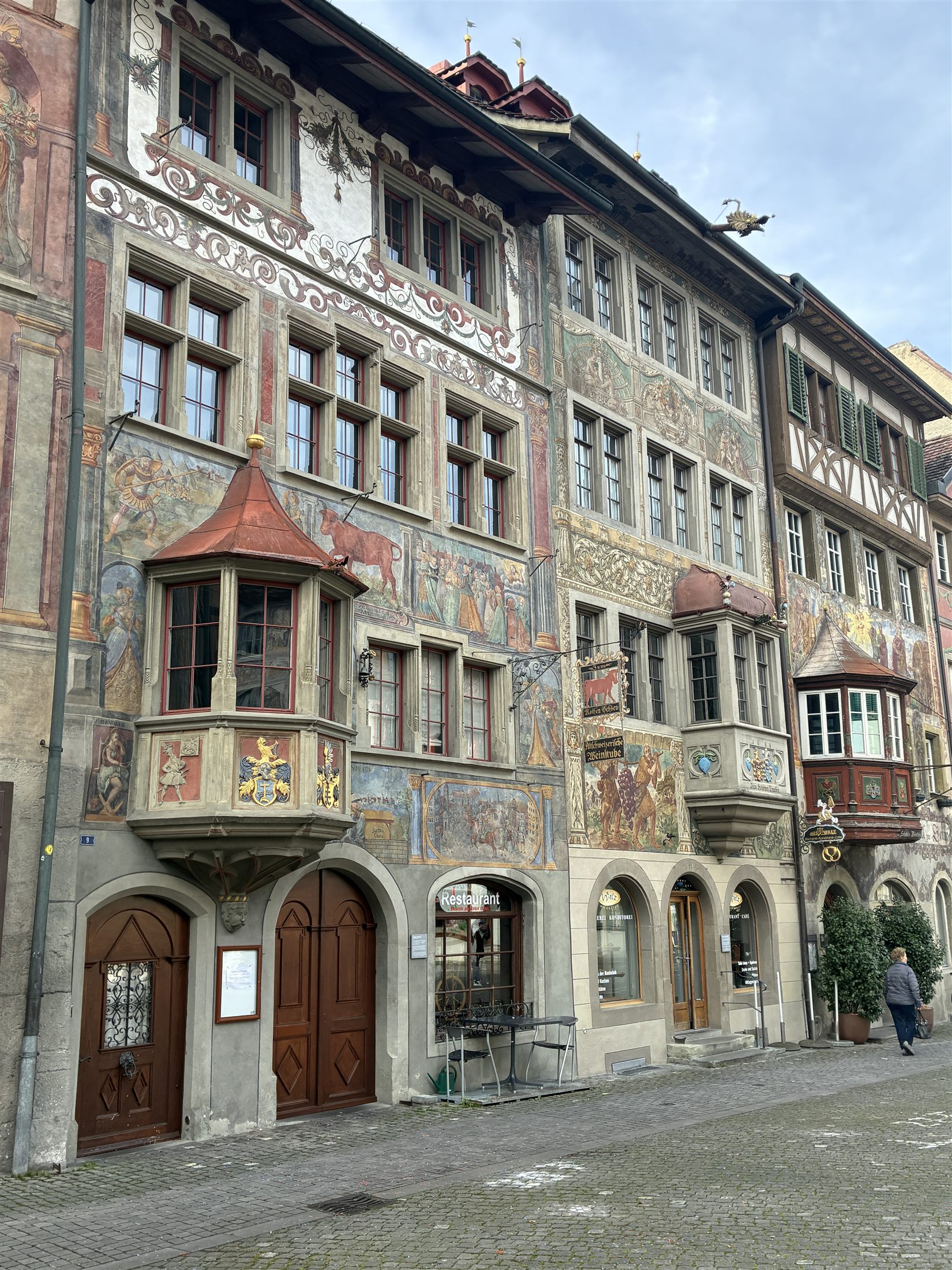 Conjunto de casas medievais com fachadas pintadas a fresco na Rathausplatz de Stein am Rhein, ao longo de rua calçada