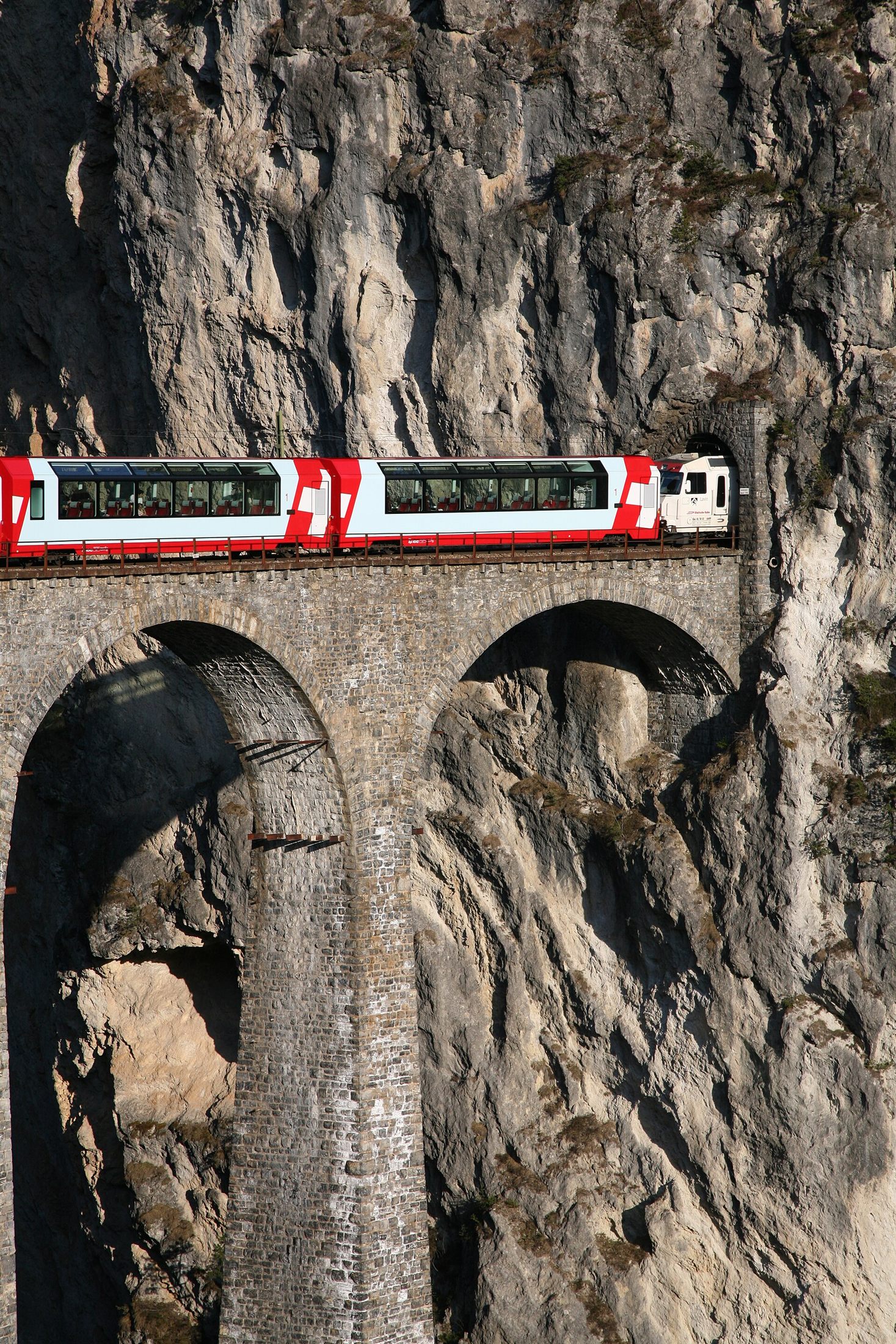 Bernina Express cruzando o Viaduto de Landwasser, arcos de calcário de 65 metros sobre o rio na Ferrovia Rética