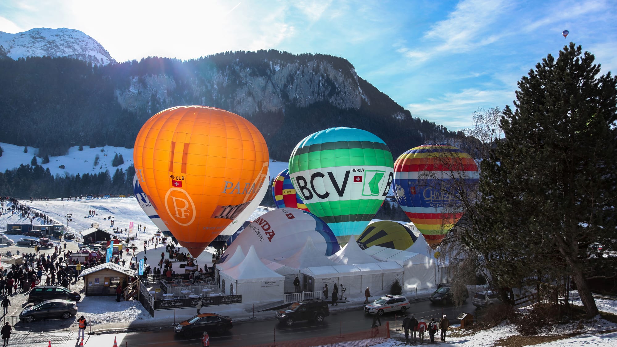 Balões de ar quente coloridos sobrevoando os Alpes durante o Festival de Baloes de Château-d'Oex, perto de Gstaad