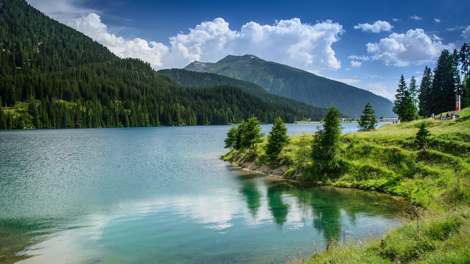 Lago de Davos no verão com reflexo das montanhas dos Grisões na água calma