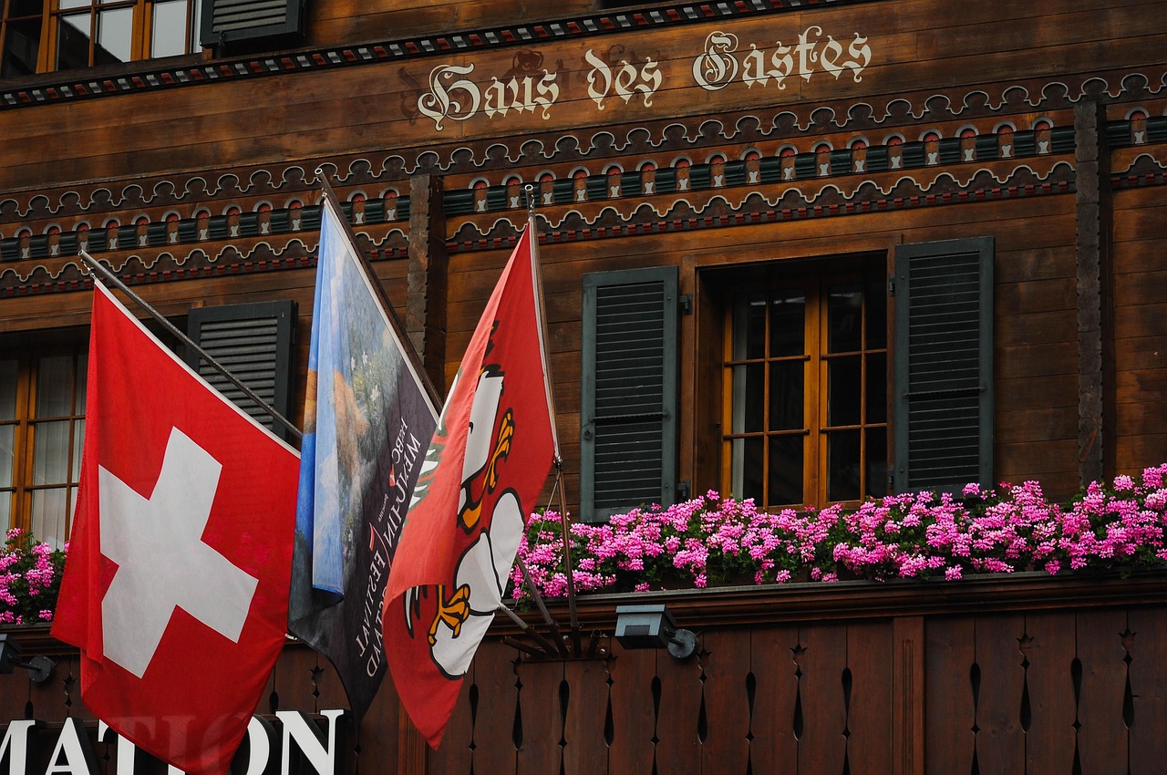Chalés de madeira entalhada com geraniums nas janelas no vilarejo de Gstaad, Suíça