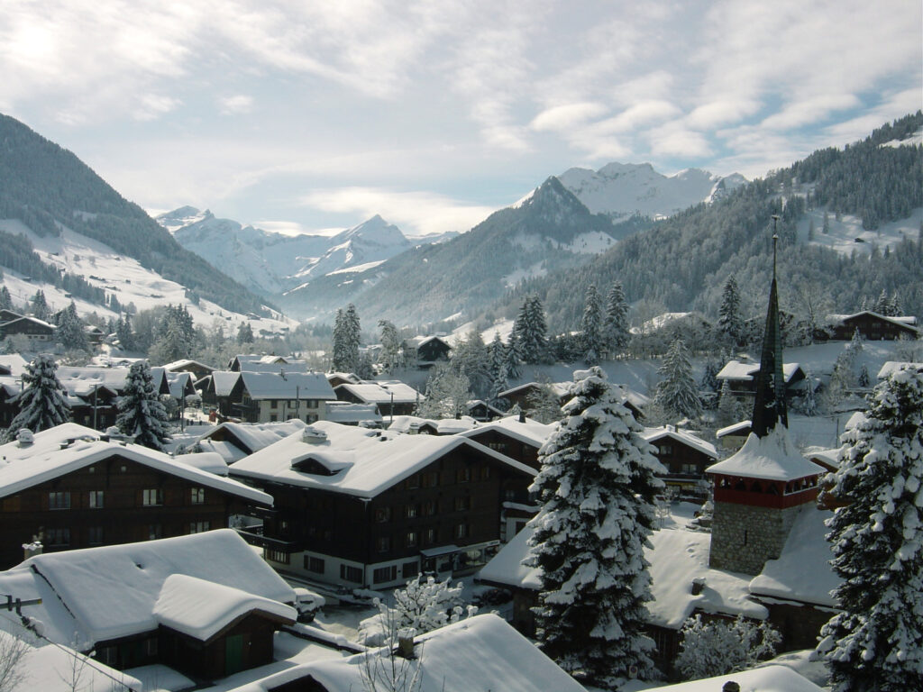 Telhados e montanhas cobertos de neve em Gstaad