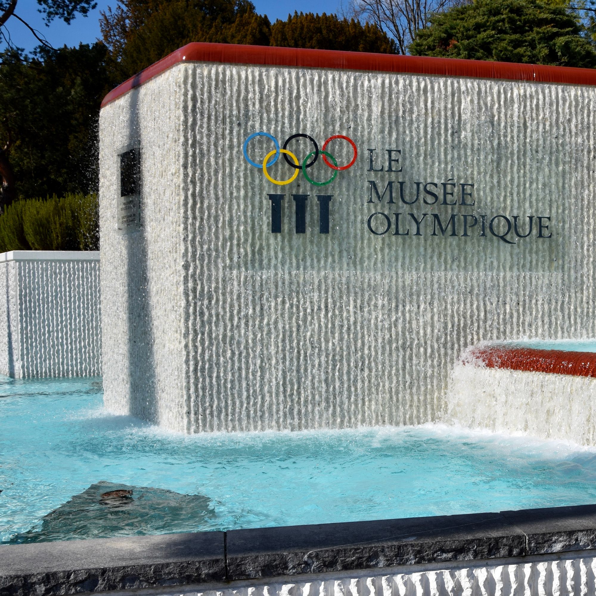 Muro d'água com os anéis olímpicos e o letreiro Le Musée Olympique, na entrada do museu em Ouchy, Lausanne