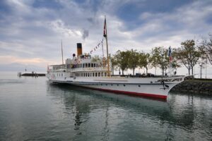 Barco a vapor da CGN atracado na orla de Ouchy, em Lausanne, com o Lago Léman e os Alpes de Sabóia ao fundo