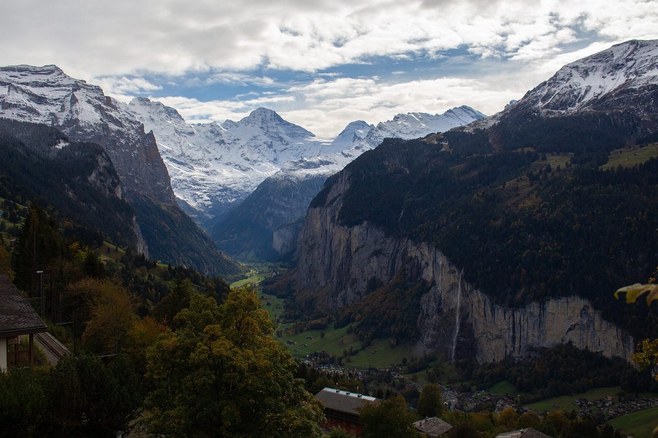 Vista elevada do Vale de Lauterbrunnen, com paredes verticais de calcário, cachoeiras laterais e o vilarejo no fundo do vale