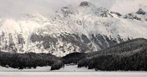 Vista panorâmica do lago de St. Moritz congelado com as montanhas dos Grisões ao fundo, Suíça
