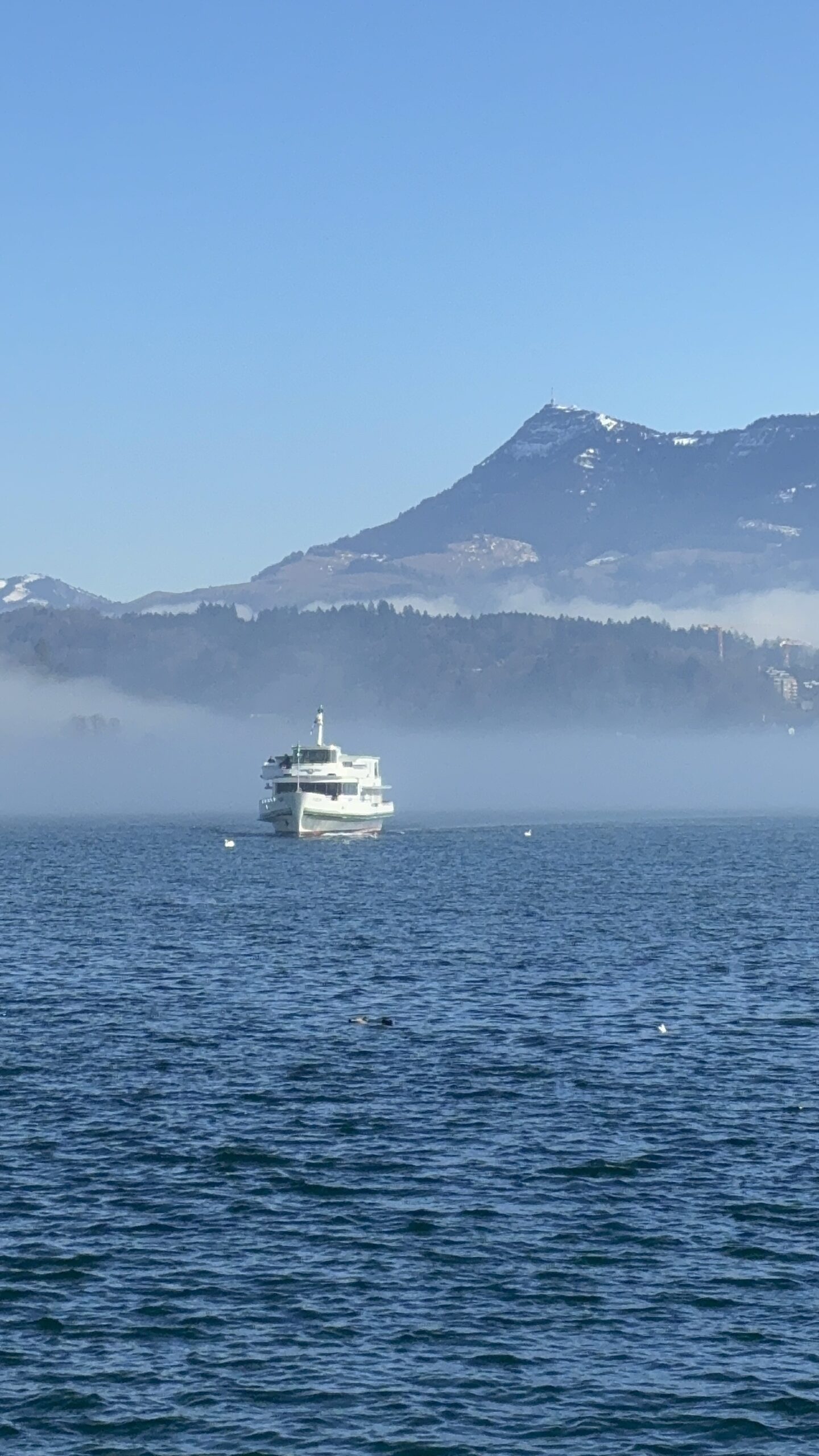 O Monte Rigi visto do Lago de Lucerna, com um barco do lago na neblina matinal