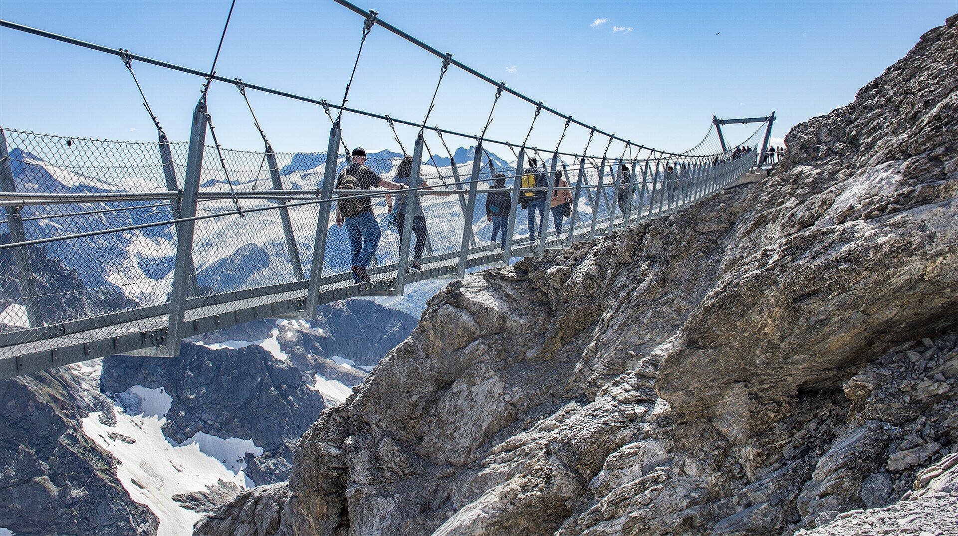 Passarela suspensa do Cliff Walk a cerca de 3.041 metros no Monte Titlis, com o abismo de cerca de quinhentos metros abaixo e os Alpes Centrais ao fundo, Engelberg