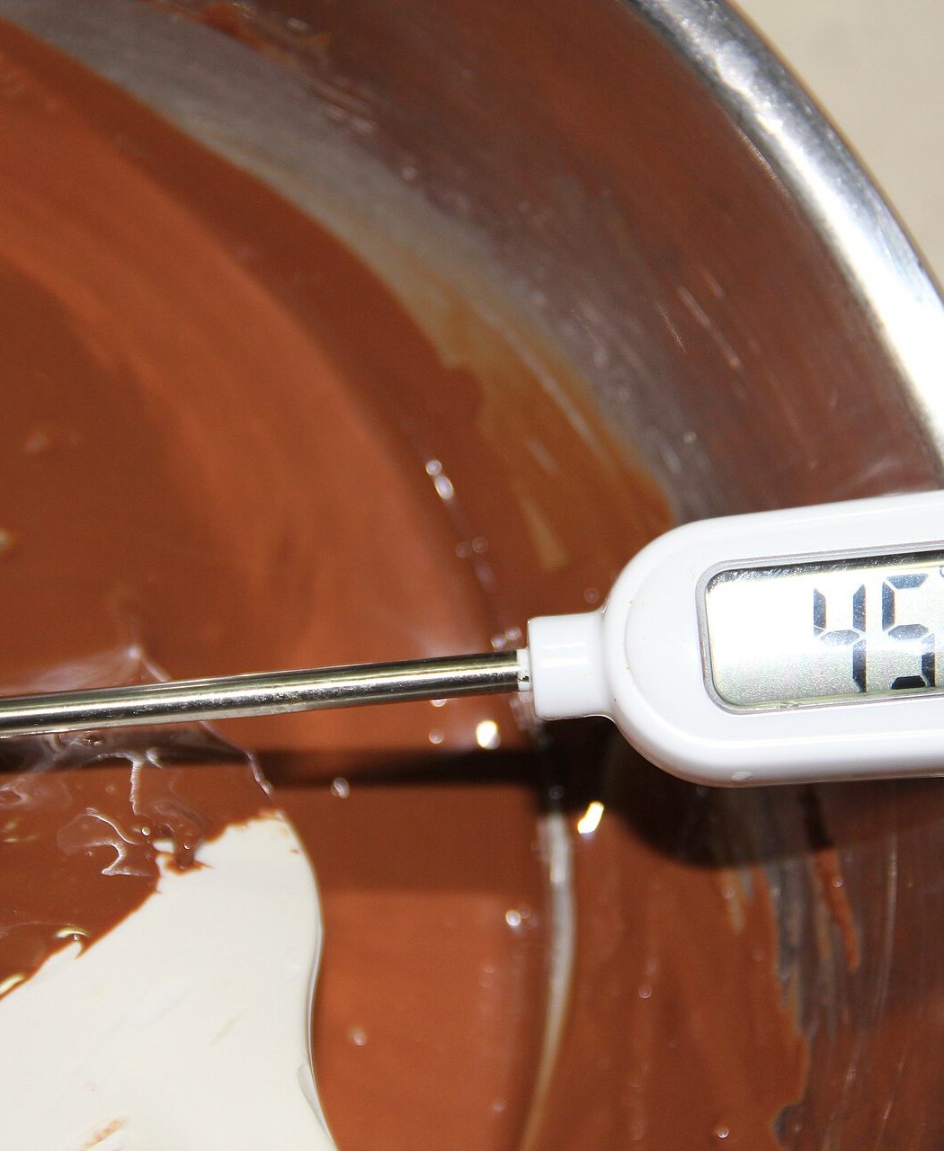 Temperagem do chocolate derretido, medido com termômetro, etapa central do workshop de chocolate suíço