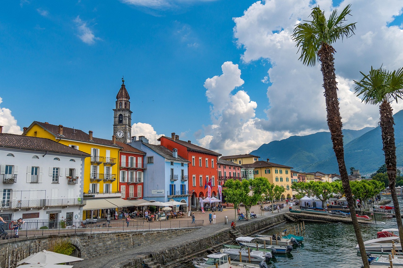 Casas coloridas de Ascona à beira do Lago Maggiore, com palmeiras, na riviera do Ticino