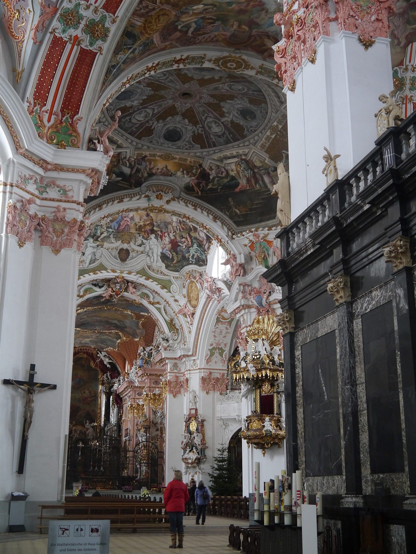 Uma nave lateral barroca da igreja abacial de Einsiedeln, com altares, afrescos e um crucifixo
