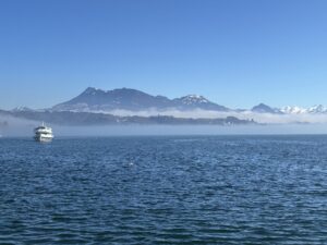 Lago de Lucerna com um barco de passageiros e montanhas nevadas dos Alpes ao fundo