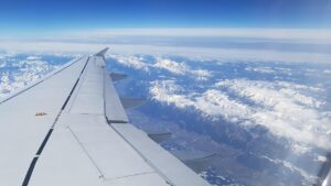 Asa de avião sobre os Alpes nevados, a caminho da Suíça
