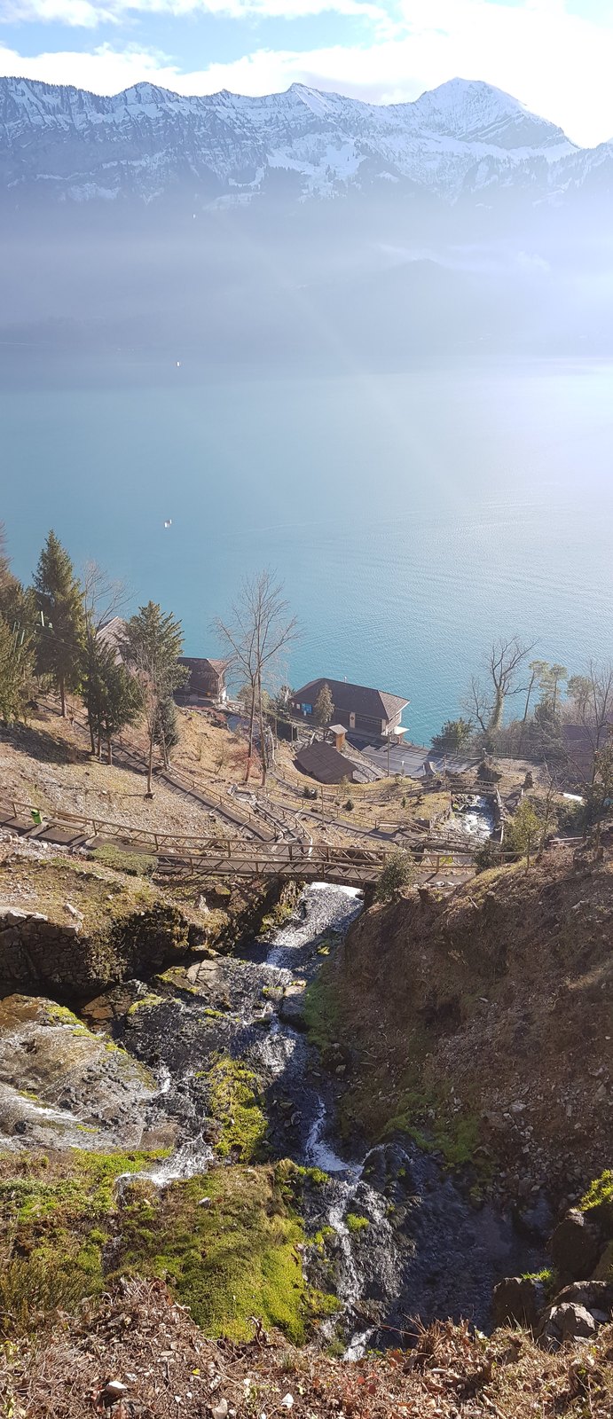 Mirante rochoso sobre o Lago Thun, com vista aberta para a água e as montanhas do Oberland bernês