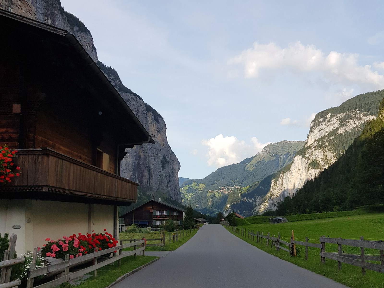 Estrada entre chalés no vale de Lauterbrunnen, com os paredões dos dois lados