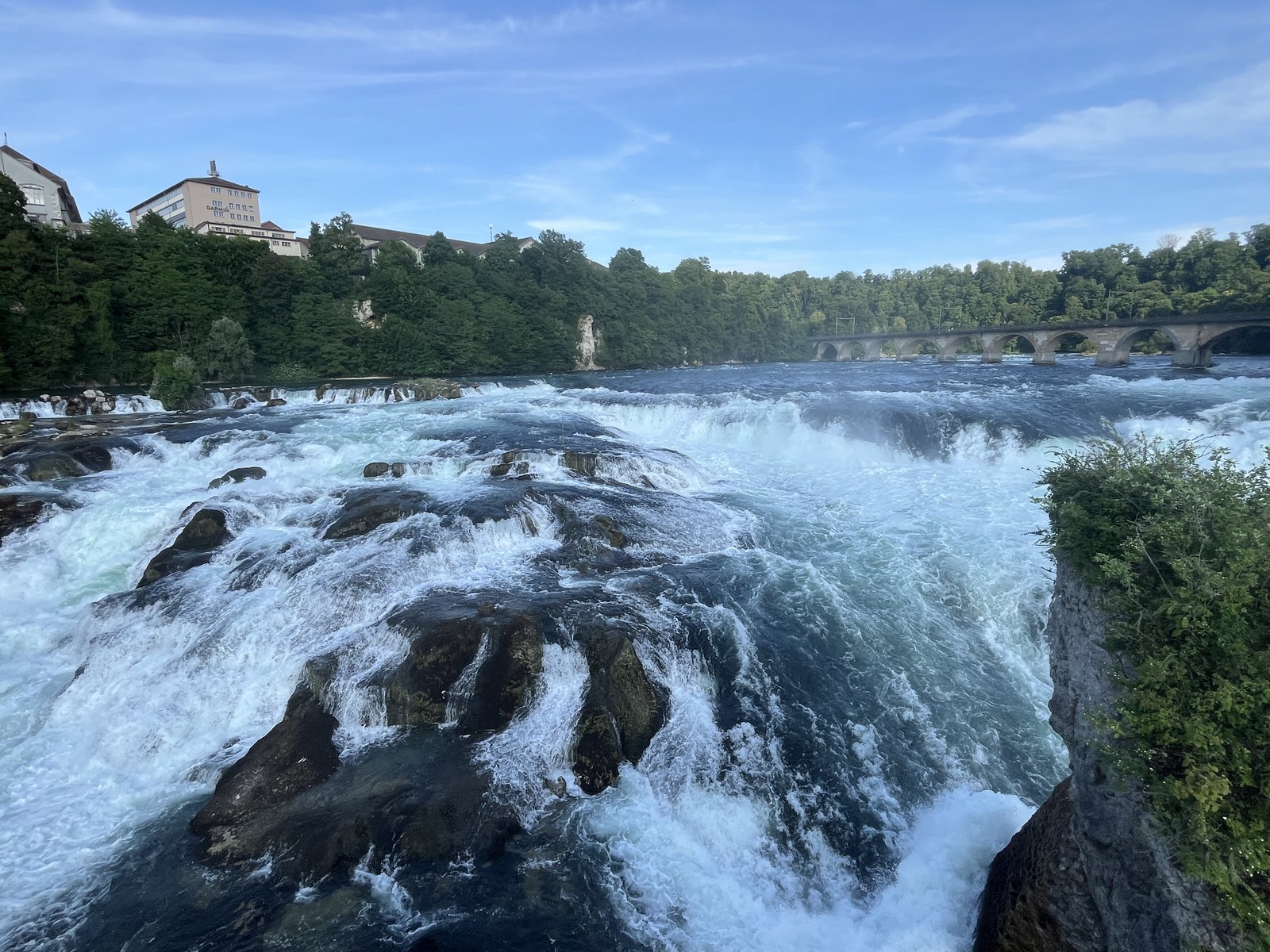 Panorama do Rheinfall com as corredeiras se espalhando entre as margens rochosas