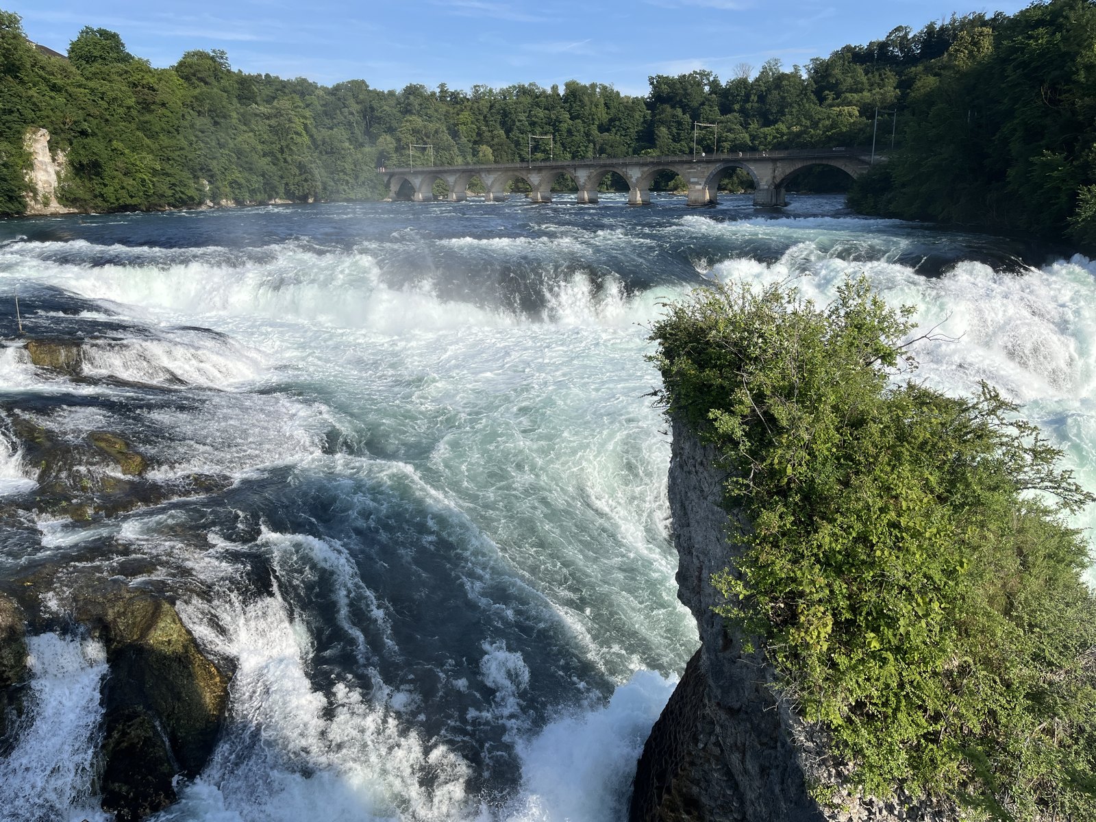Ponte ferroviária histórica sobre o Rheinfall, com trem cruzando ao fundo