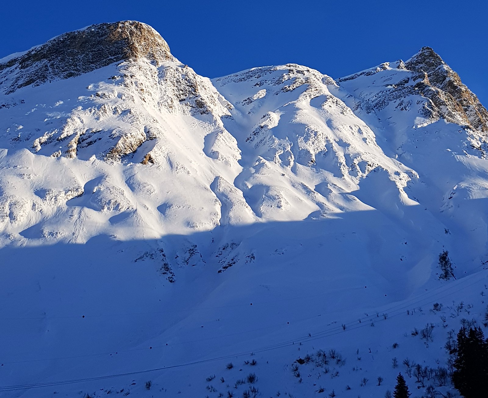 Picos nevados iluminados pelo sol baixo na região do passo de San Bernardino