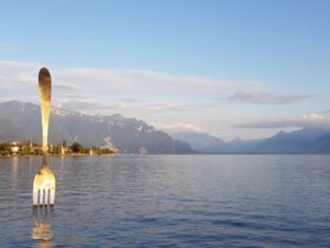 Garfo gigante La Fourchette cravado no Lago Léman ao entardecer
