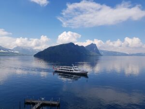 Barco de passageiros no Lago de Lucerna espelhado perto de Weggis