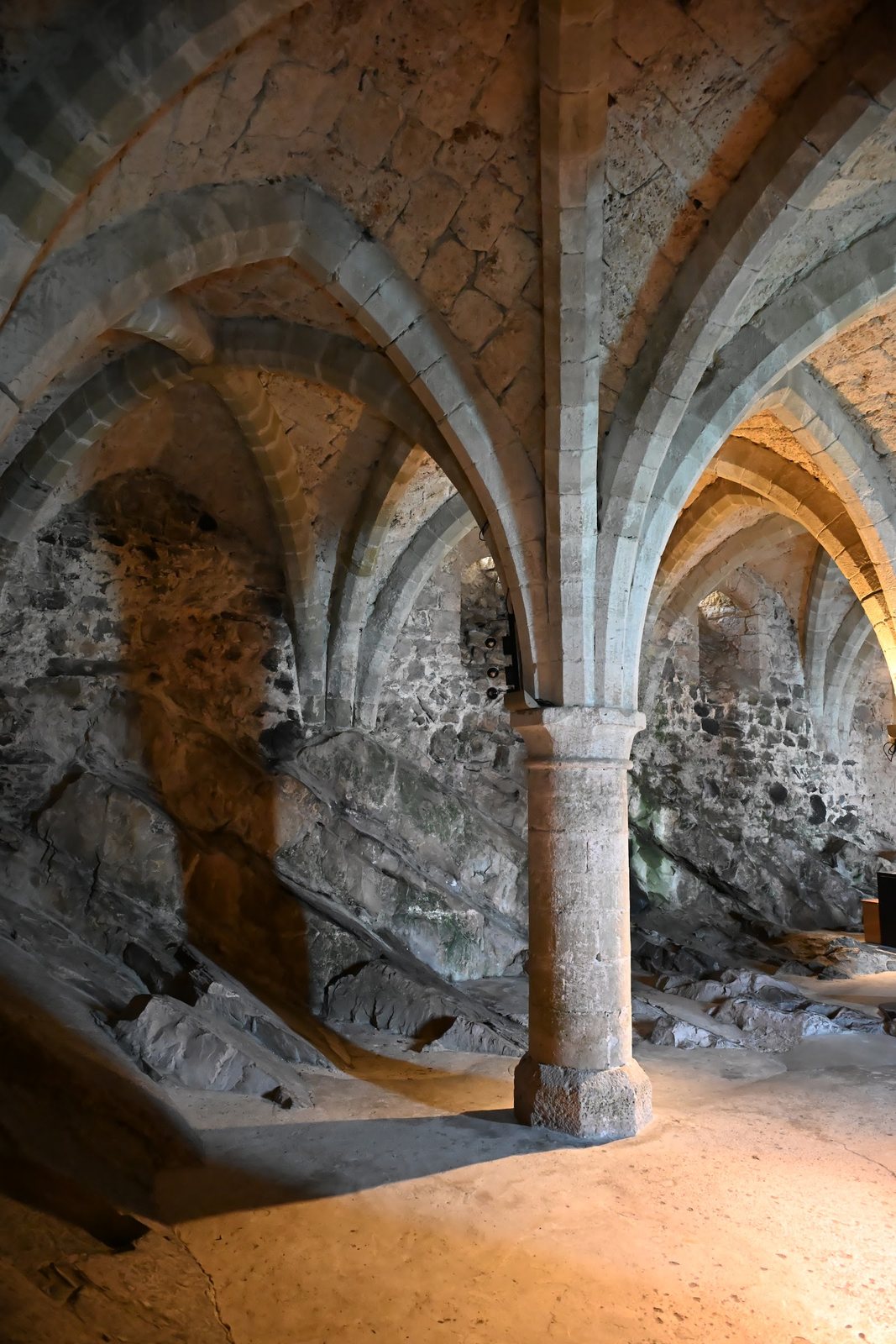 Rocha calcária da ilha de Chillon sob as abóbadas do subterrâneo, com pilar de pedra ao centro