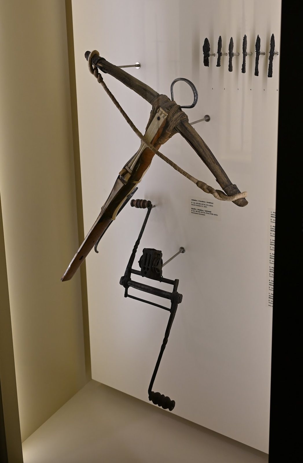Besta do século XV numa vitrine do Castelo de Chillon, com uma moufle de armar e uma fileira de pontas de ferro