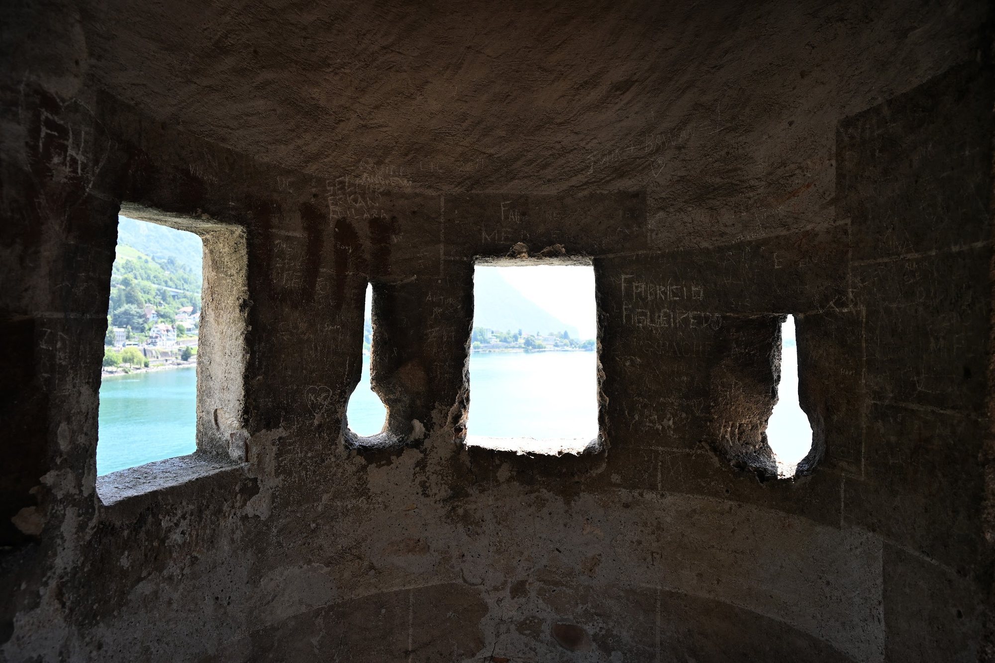 Sala de torre do Castelo de Chillon com aberturas em forma de buraco de fechadura e aberturas quadradas voltadas para o lago