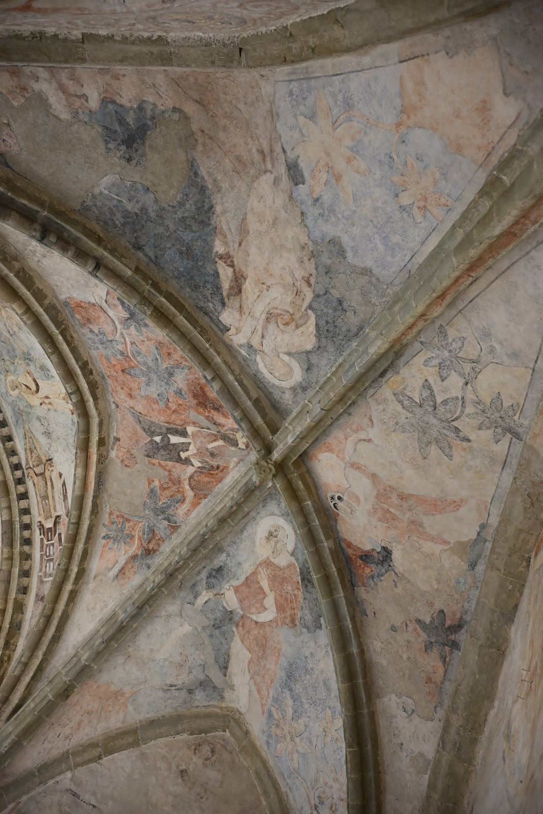 Detalhe das abóbadas pintadas da capela de Chillon, com nervuras góticas, figuras com auréola e motivos vegetais em ocre e azul