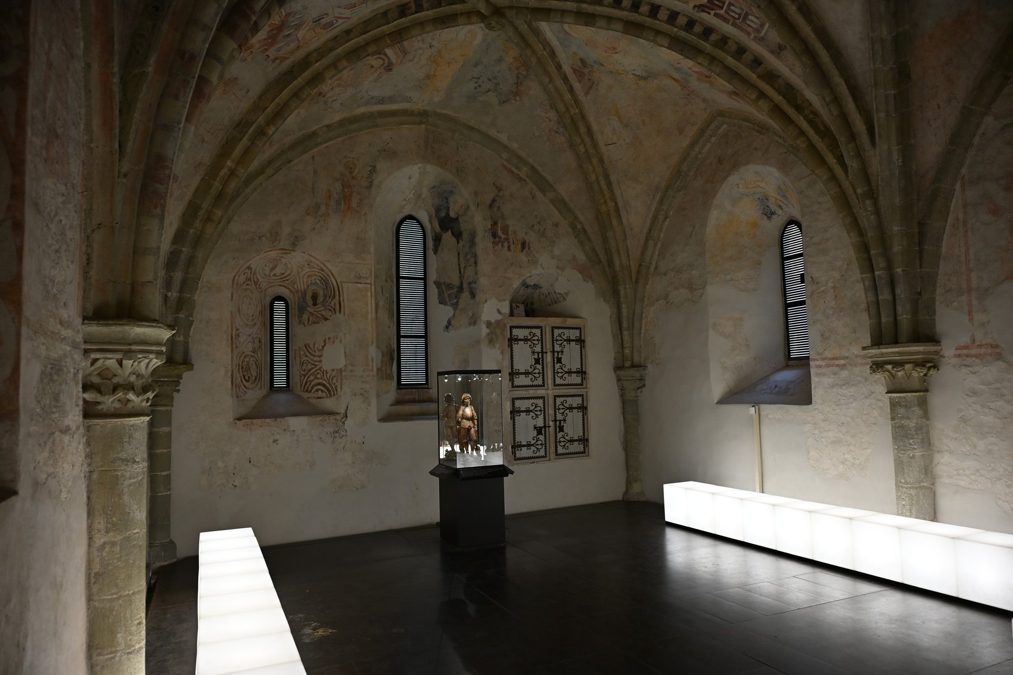 Capela de são Jorge do Castelo de Chillon com abóbadas góticas pintadas, janelas estreitas e a vitrine com a estátua de são Jorge