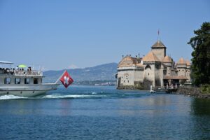 Vapor da CGN com a bandeira suíça passando diante do Castelo de Chillon, no Lago Léman