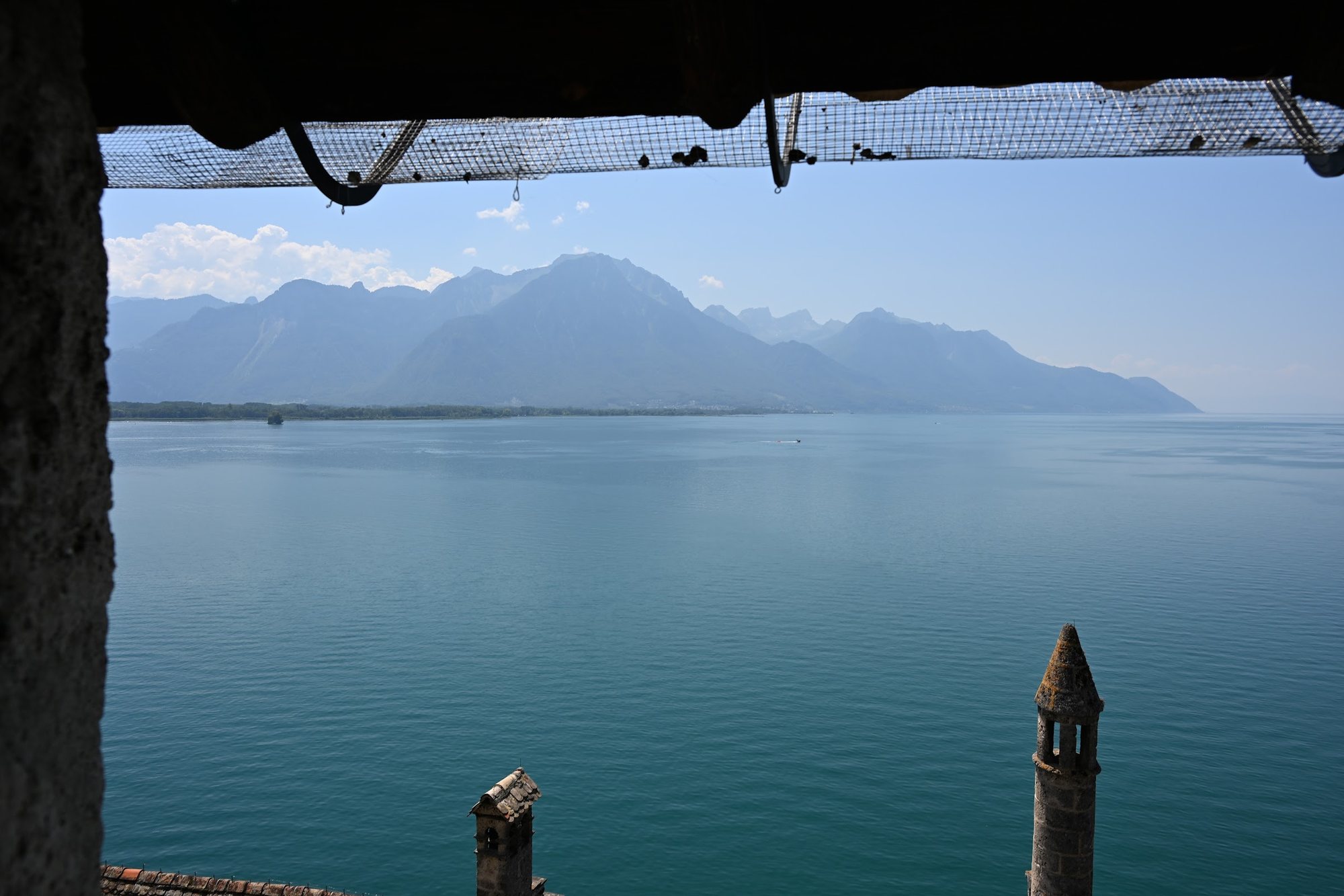 Lago Léman visto da galeria coberta do Castelo de Chillon, com os telhados e as montanhas do Chablais ao fundo