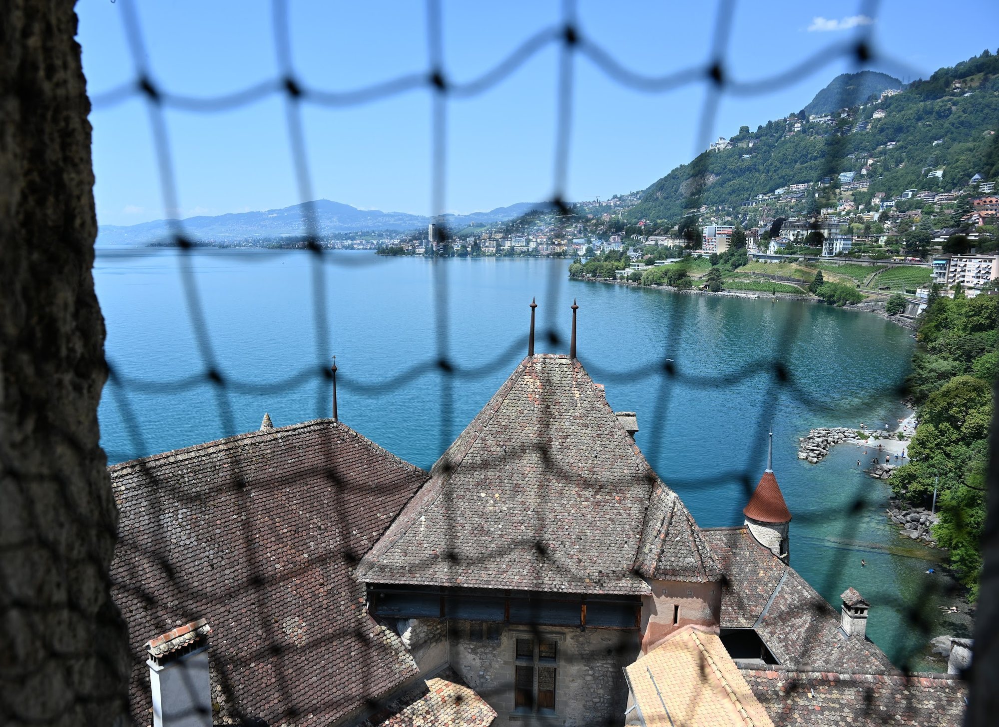 Montreux vista do alto de uma torre do Castelo de Chillon, com a baía do Lago Léman e a cidade subindo a encosta