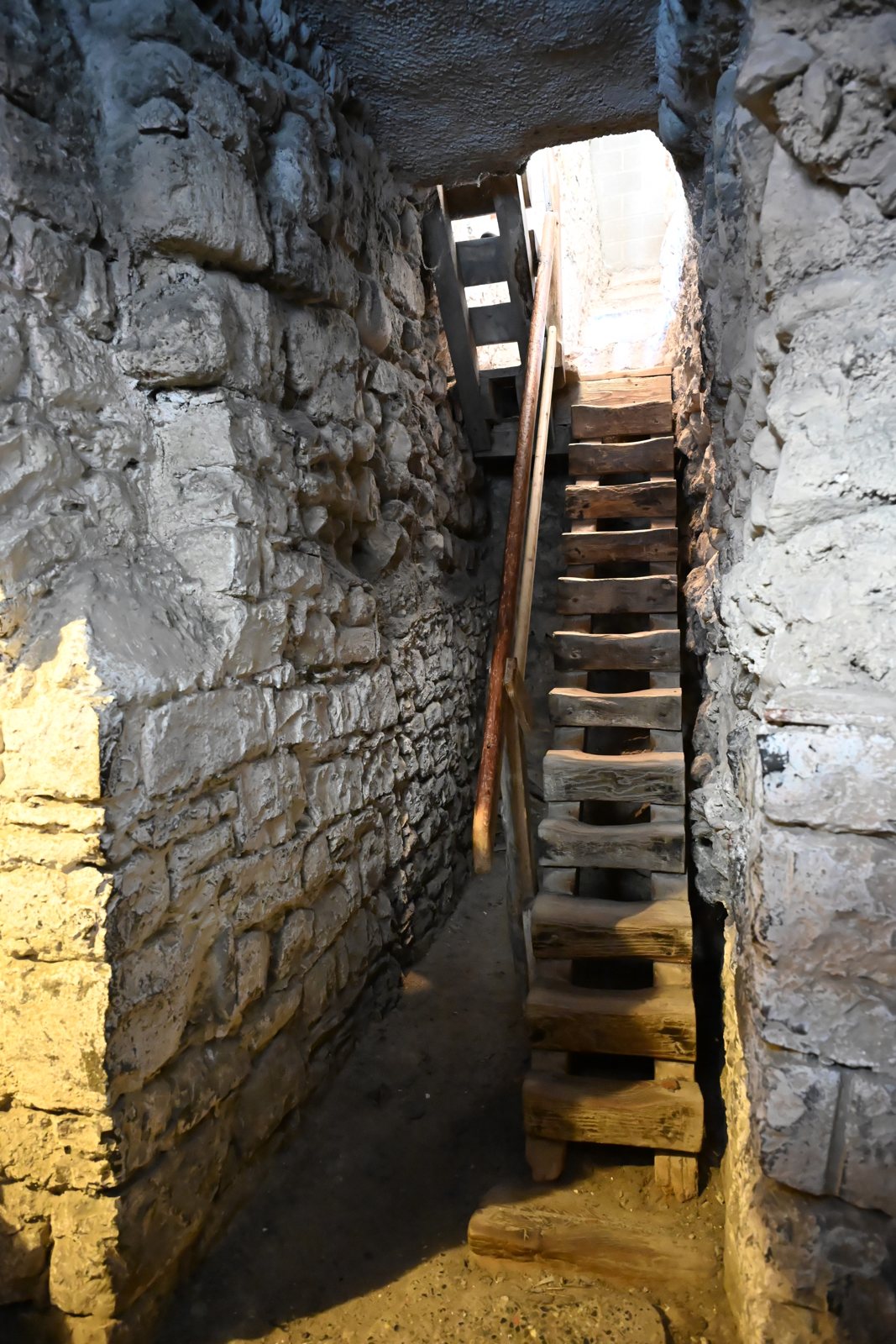 Escada de madeira íngreme entre duas paredes de pedra no Castelo de Chillon