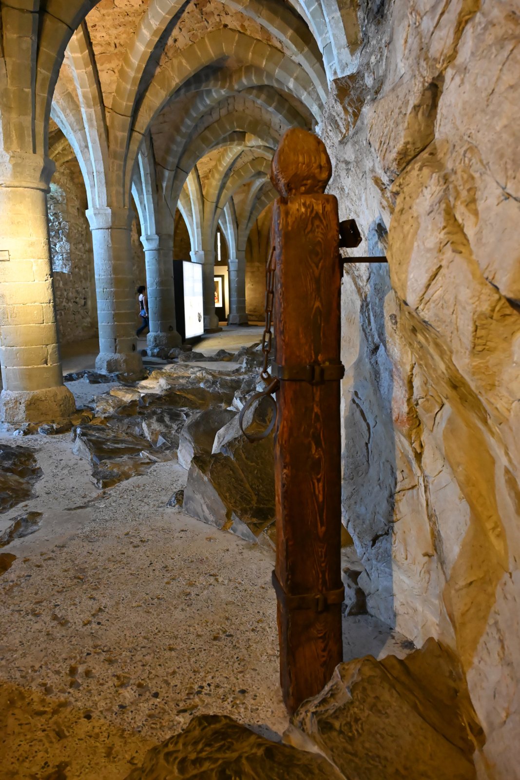 Poste de madeira com corrente de ferro junto a um pilar na prisão de Chillon