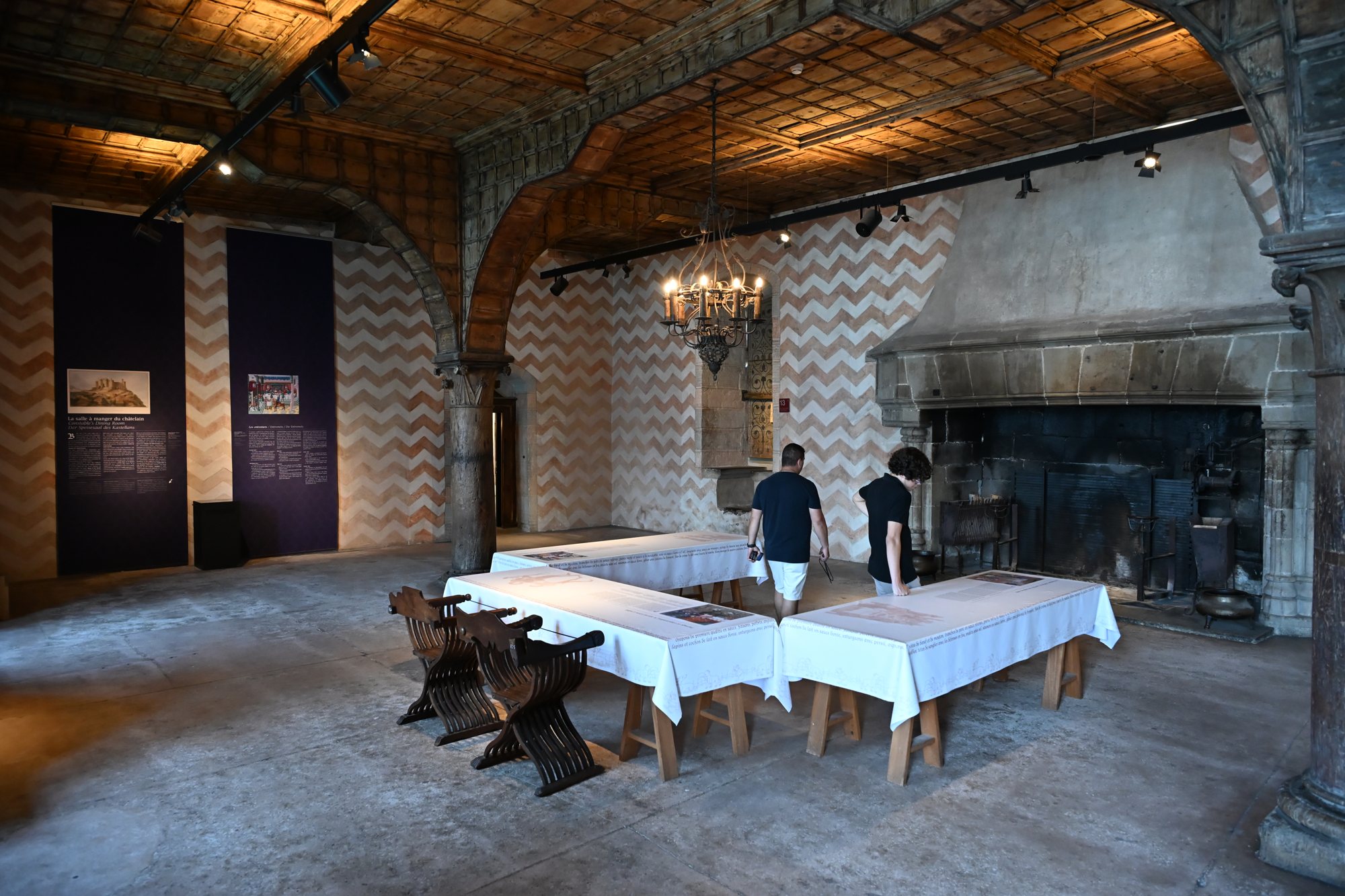 Sala de jantar do castelão em Chillon, com lareira monumental e mesa de madeira
