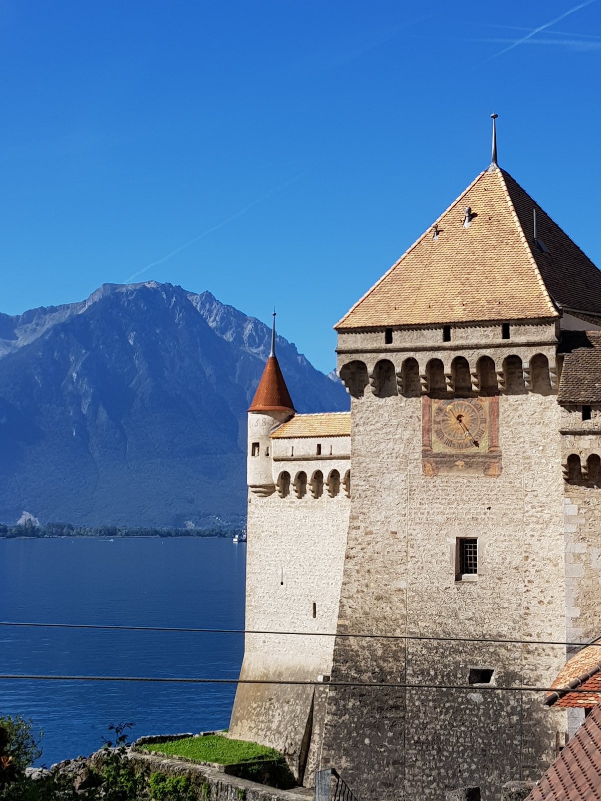 Torre do relógio do Castelo de Chillon em setembro, com a montanha do outro lado do Lago Léman