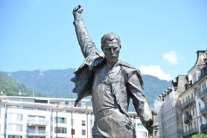 Estátua de bronze de Freddie Mercury em Montreux vista de baixo, punho erguido contra o céu azul