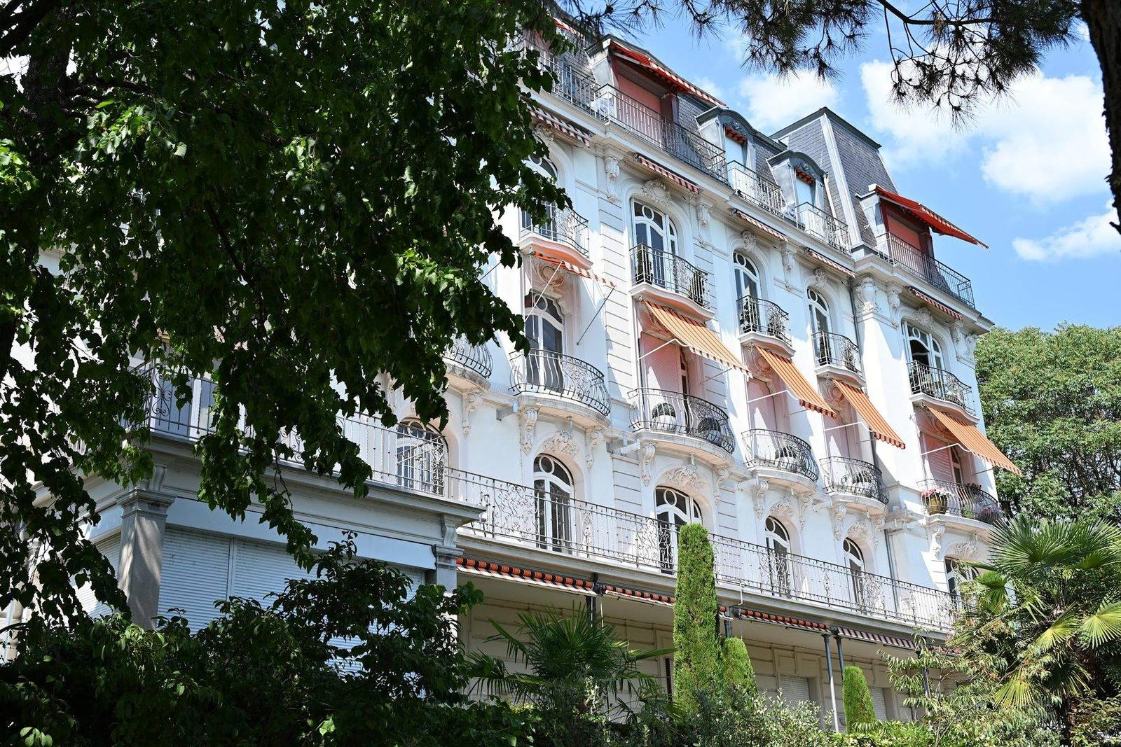 Fachada de hotel Belle Époque em Montreux com toldos laranja