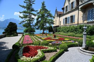 Parterre de flores do Castelo de Oberhofen descendo ate o Lago Thun, com a montanha Niesen ao fundo